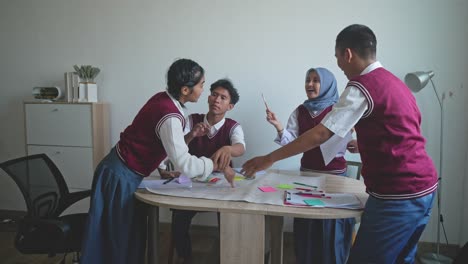 asian high school students arguing and fighting when doing school work together at the study room
