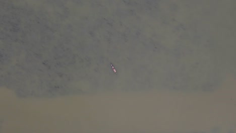 barco de pesca asiático en medio del gran río marrón, bangladesh, antena aérea