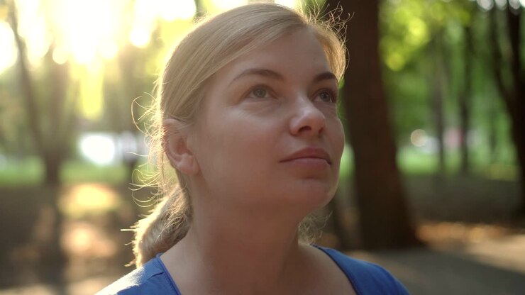 A woman removes a medical mask in a Park 03