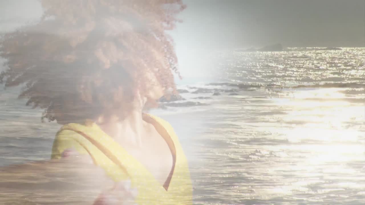 Animation of happy african american woman at beach over sun reflecting on sea