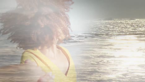 animation of happy african american woman at beach over sun reflecting on sea