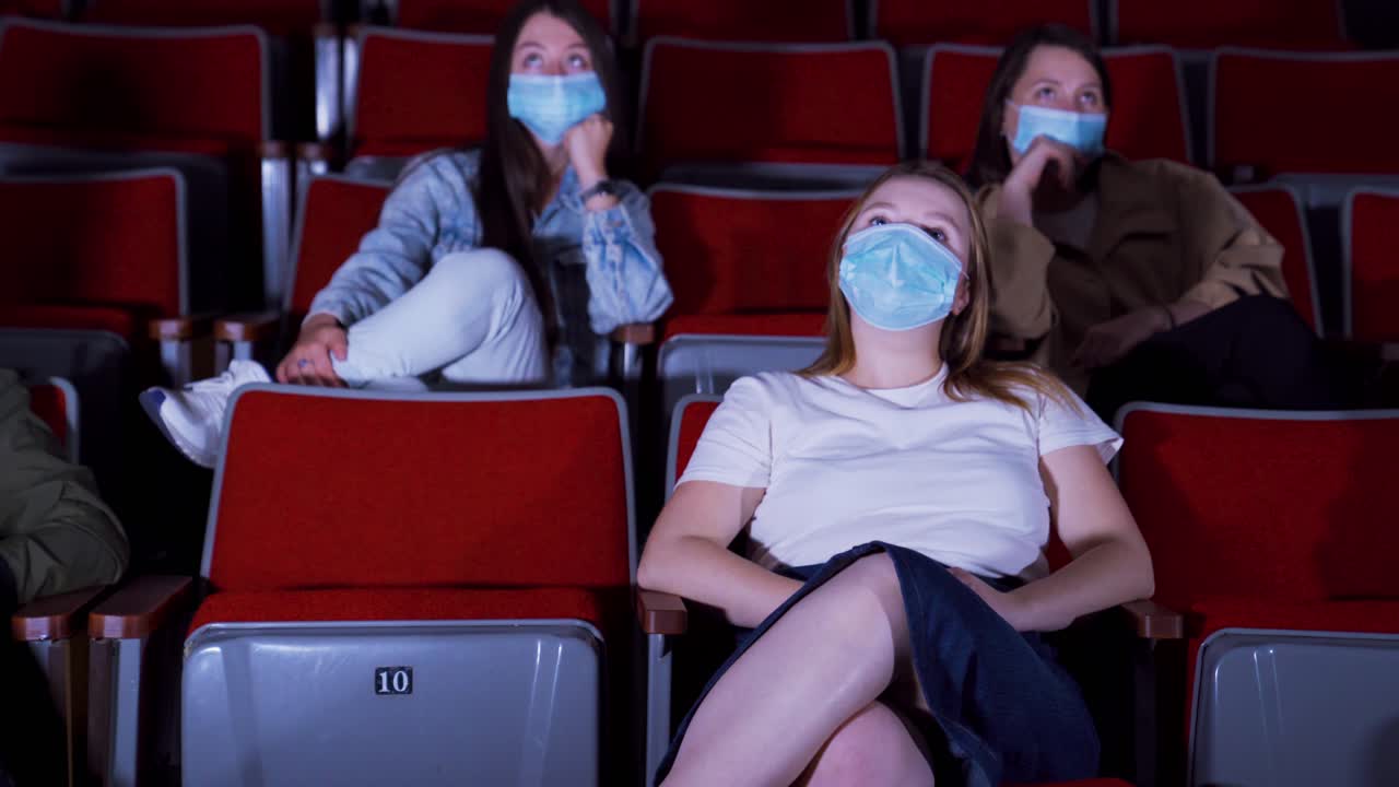 personas viendo una película en un cine durante la pandemia