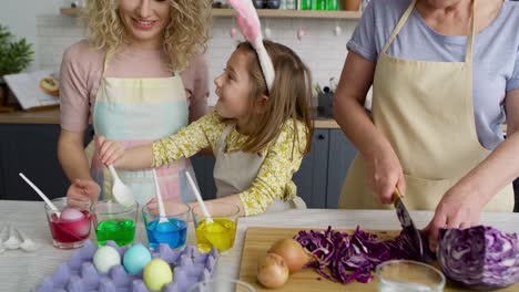 Zoom-out-of-three-generations-of-women-preparation-Easter-eggs
