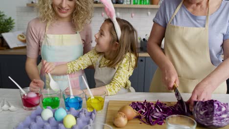 zoom out of three generations of women preparation easter eggs