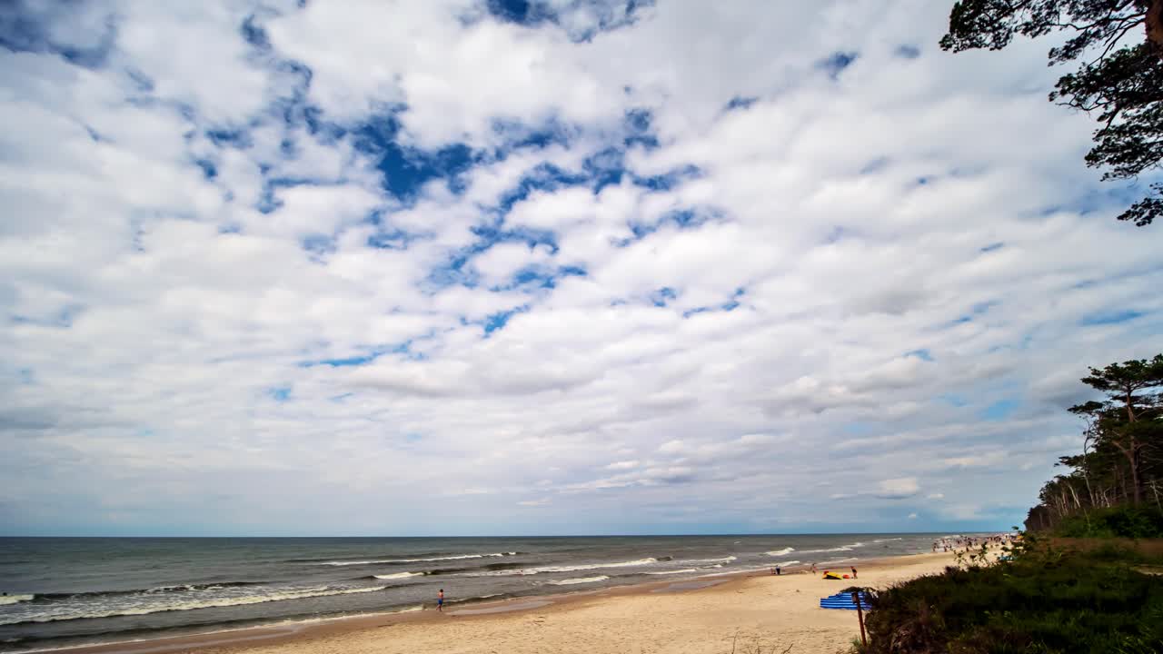 Time-lapse di nuvole bianche su cielo blu che si muovono sopra una spiaggia sabbiosa del Mar Baltico in Polonia