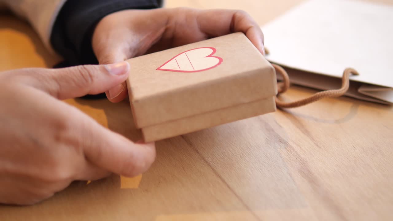 Unboxing a gift with a heart sticker
