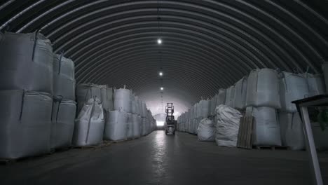 warehousing. forklift driver stacking big bag of raw material in warehouse. 
many bags of raw materials in the warehouse