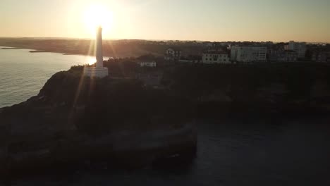 sunbeams illuminating biarritz lighthouse at sunset, france