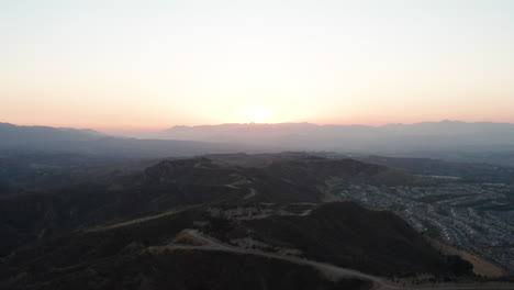 Vista-Aérea-De-La-Puesta-De-Sol-Sobre-Las-Carreteras-De-Montaña-En-El-Sur-De-California