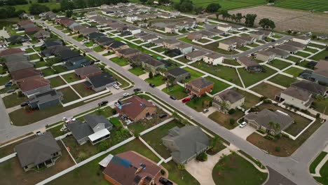 residential neighborhood in brandon, florida, with neatly arranged homes with well-kept lawns and wide streets. the area reflects a peaceful suburban environment. modern solar panels on roof. aerial.