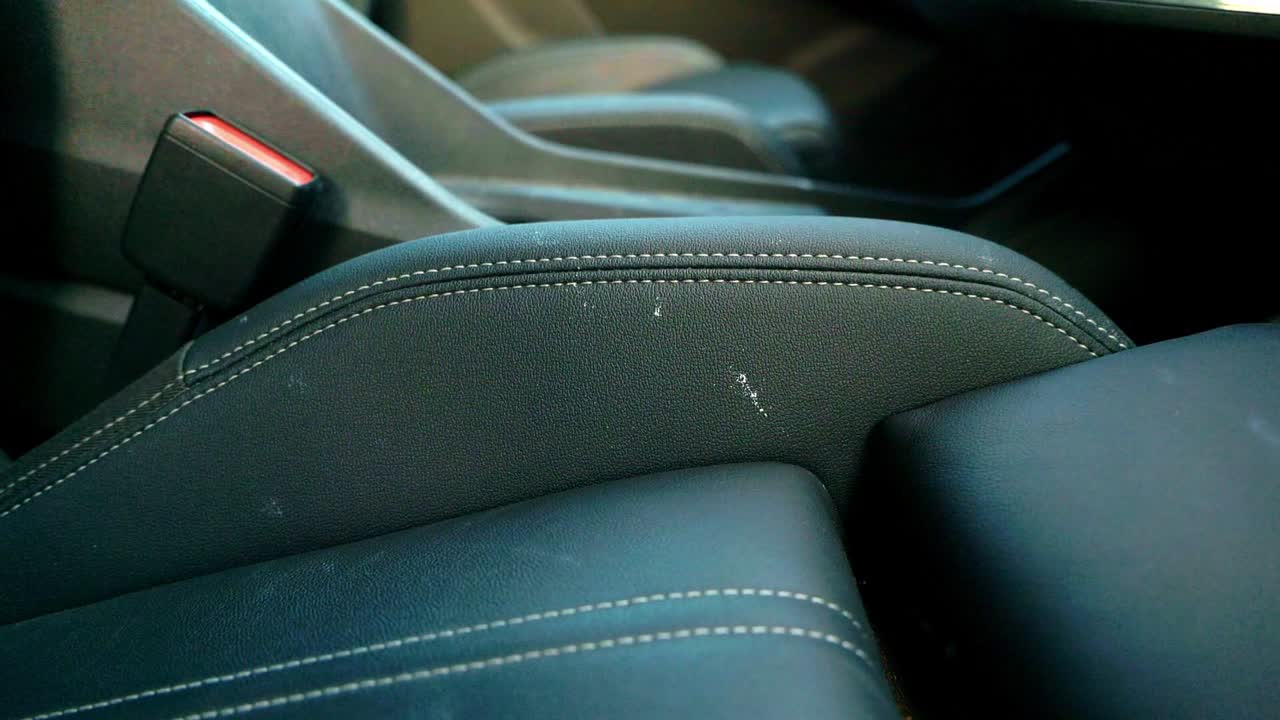 White paint on black leather car seat bolster