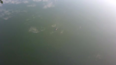 distant view of a traditional dugout canoe in lake bunyonyi, uganda, africa