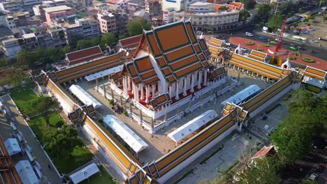 aerial medium orbit of wat suthat in bangkok, thailand, vast temple grounds and surrounding urban landscape