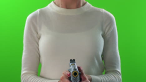 female pointing gun forward, cocking and firing on green screen background