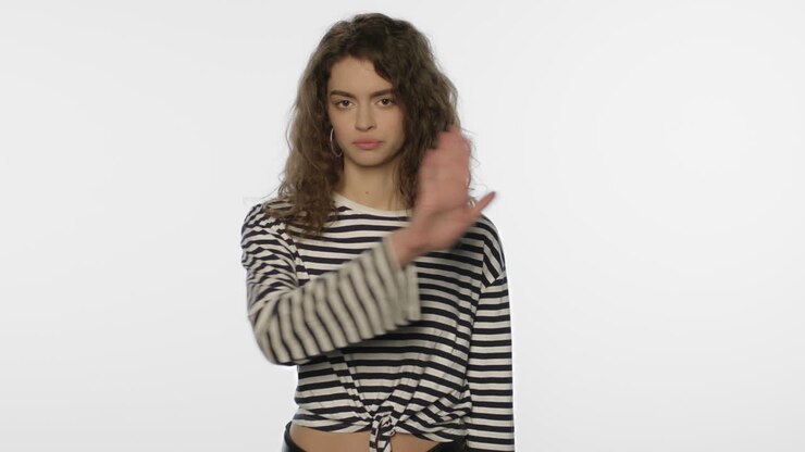Donna che fa cenno di no con la mano. Donna disinteressata che mostra un gesto negativo con la mano.
