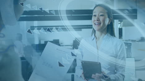 holding tablet with digital data animation, businesswoman working in office