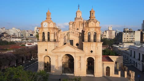 cinematic aerial dolly in shot toward the statue of christ in between two clock towers, historic monument cathedral of cordoba, argentina