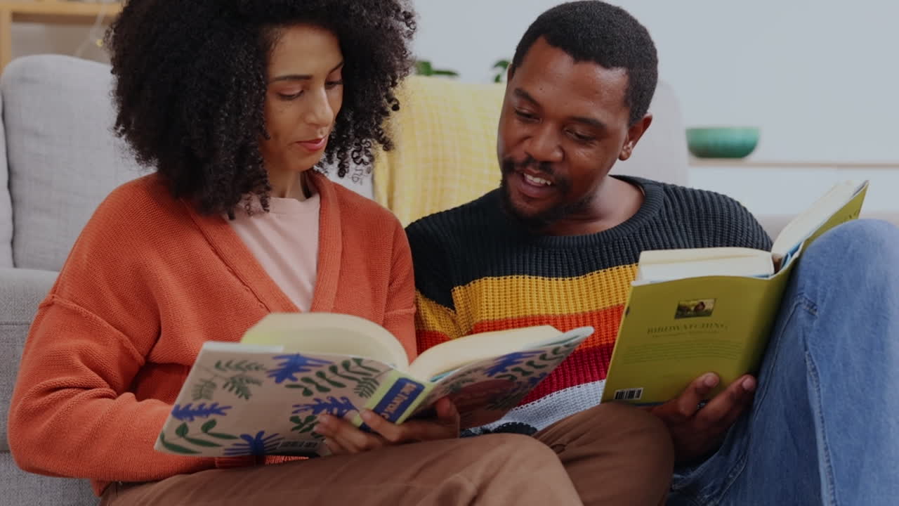 Black couple, reading and books on floor in home
