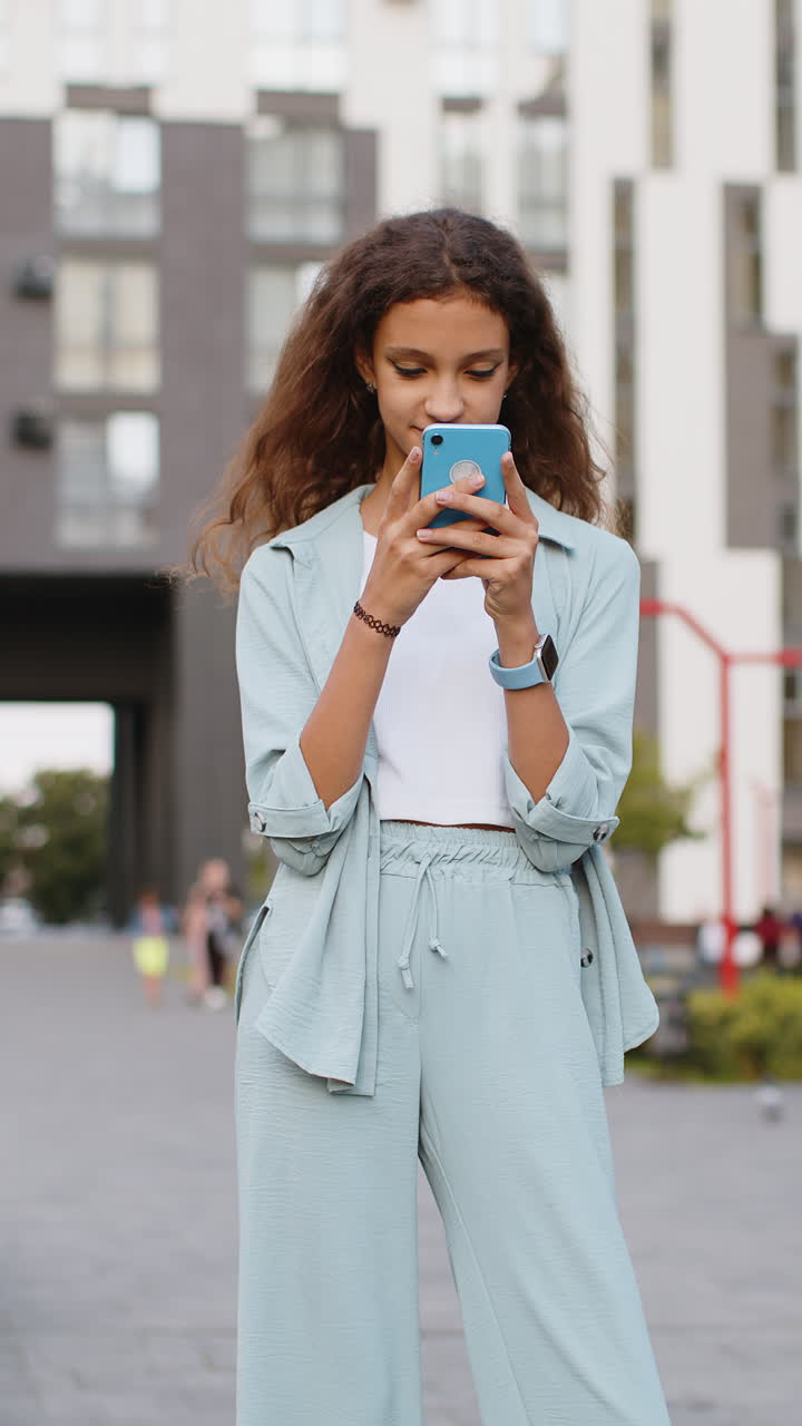 niña preadolescente usa teléfono inteligente escribe mensajes de texto navega por internet termina el trabajo mirando a la cámara