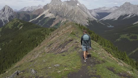 hiker walking on ridge pan to road rockies kananaskis alberta canada