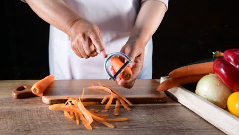 woman hands peel fresh carrot