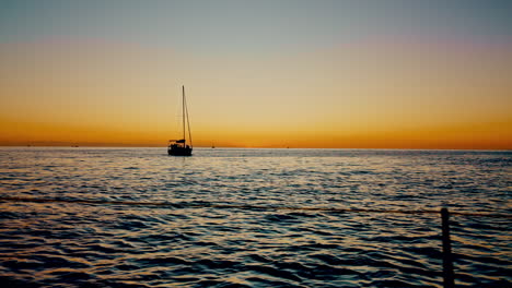 Sunset,-ocean-and-a-yacht-on-the-water-for-travel