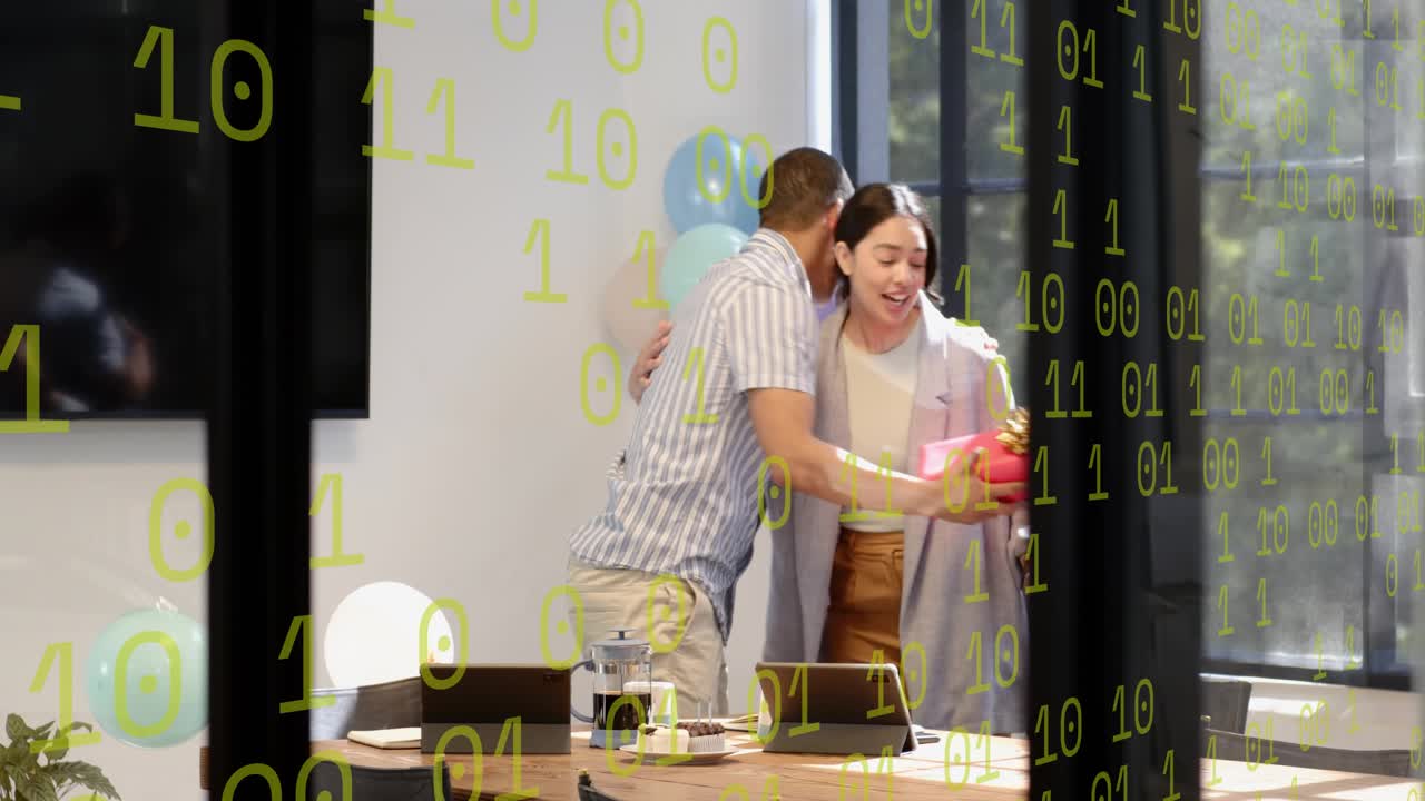 Man using tablet, noticing woman entering with red gift, reaching, taking, hugging at office party