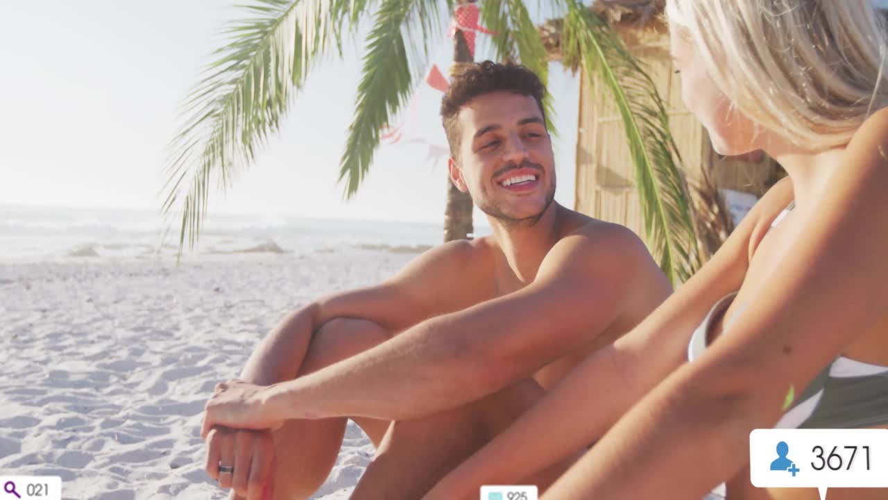 Donna e uomo che chattano sulla spiaggia, generando icone di social media che emergono e svaniscono mostrando coinvolgimento