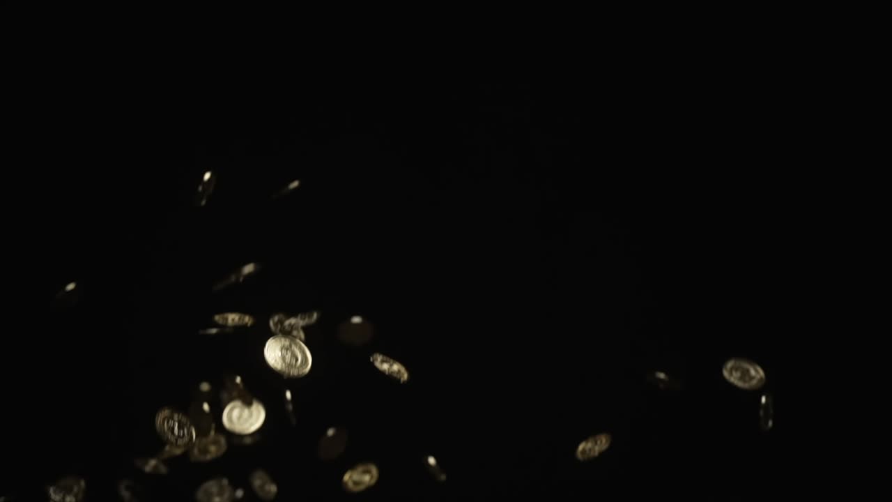 muchas monedas de oro arrojadas al aire y cayendo a cámara lenta