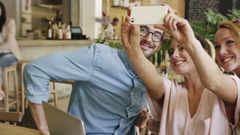 attractive friends taking self portrait photograph selfie in cafe