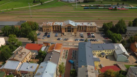 Panoramic-view-of-Daugavpils-Pass-train-station-building,-street,-and-neighborhood,-Latvia,-Drone-shot