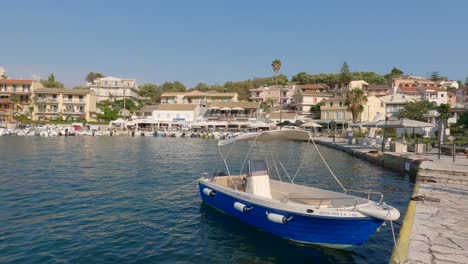 Toma-Panorámica-De-La-Bahía-De-Kassiopi,-Ciudad-Pintoresca-Frente-Al-Mar,-Pequeños-Botes-Amarrados,-Isla-De-Corfú,-Grecia