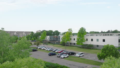 workplace-building-with-parking-lot,-aerial-dynamic