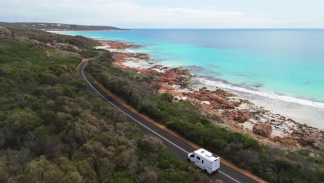 drone flying over motorhome as it drives along scenic coastal road in dunsborough, western australia
