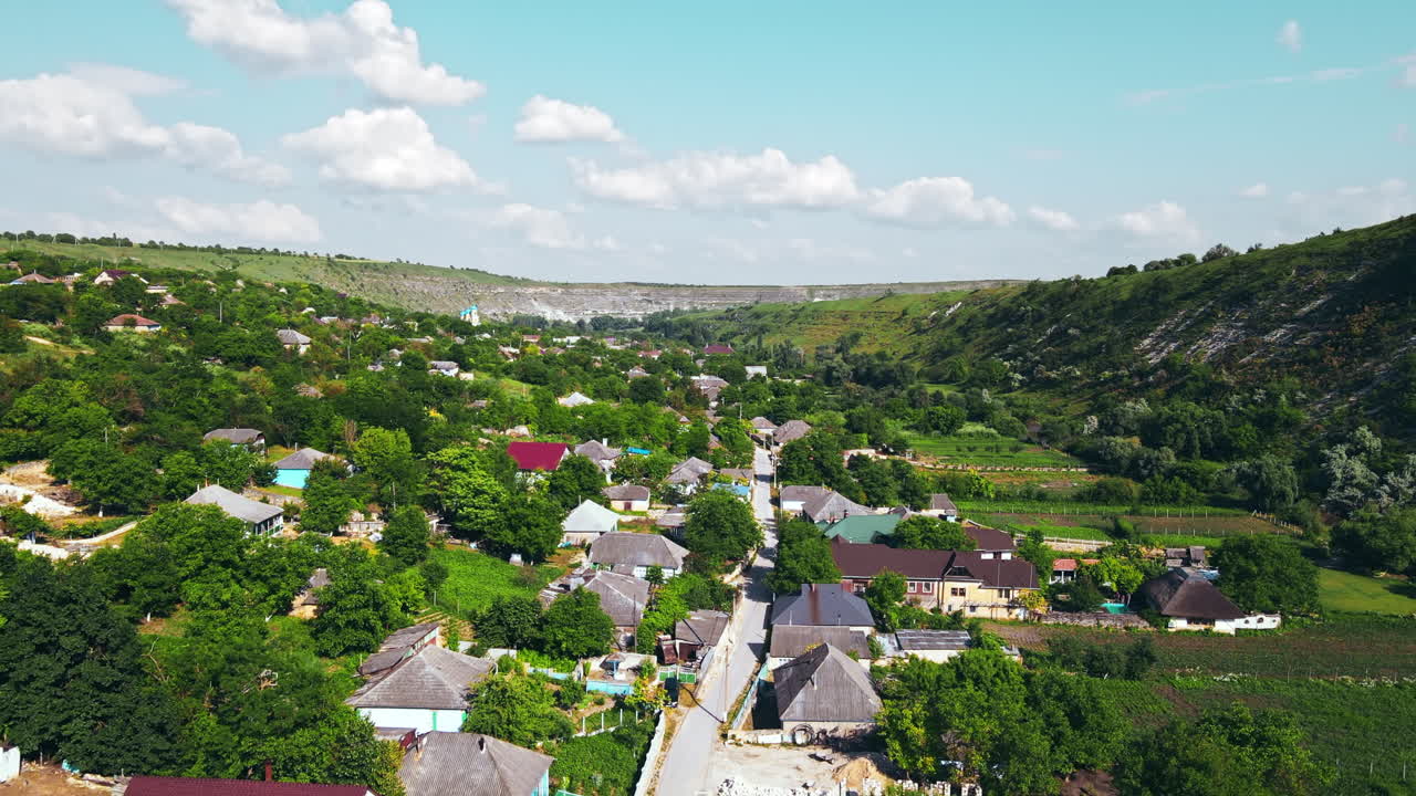 Aerial drone view of nature, valley with river and village, hills, greenery, Moldova