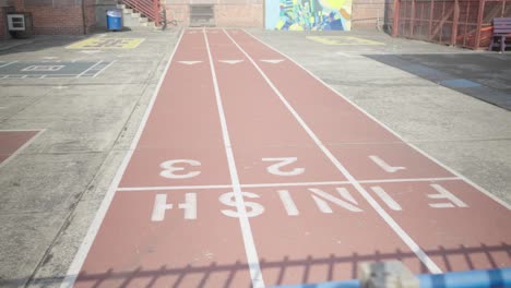 a public school courtyard proudly displays a 40-yard dash track, promising athletic feats and triumphant childhood victories