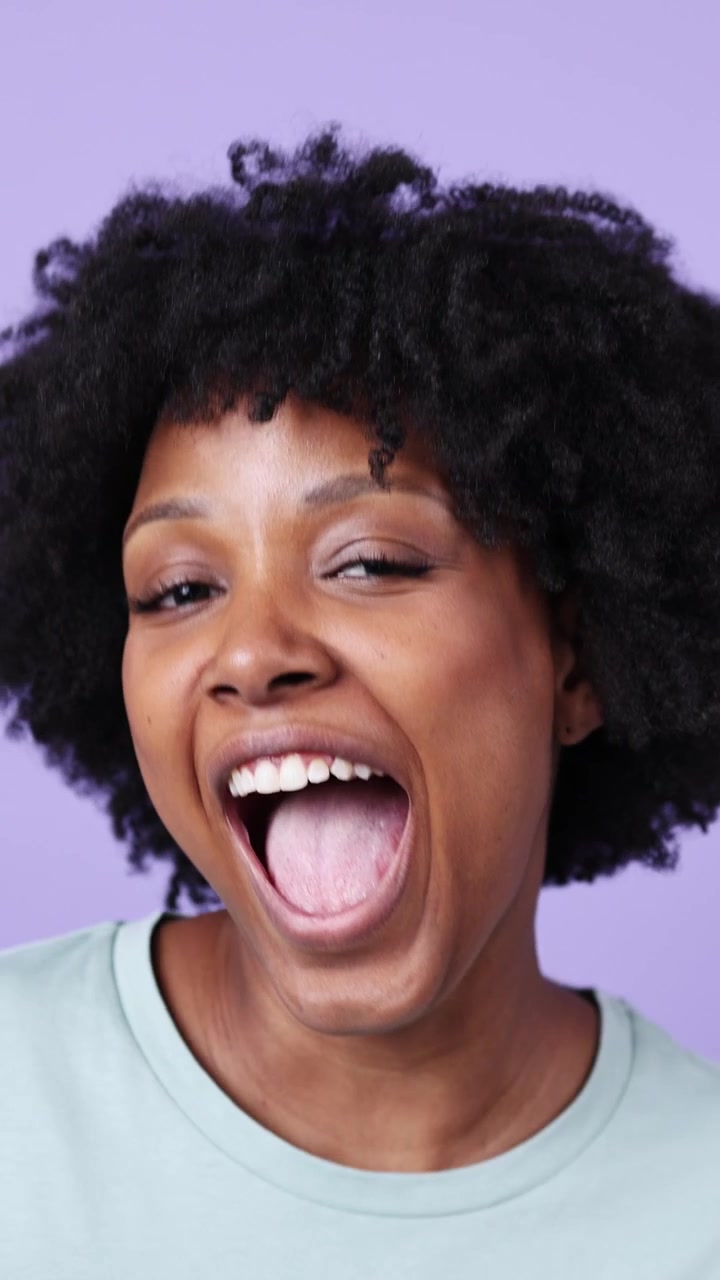 Expressive Young Black Woman with Afro Hair Winking and Smiling