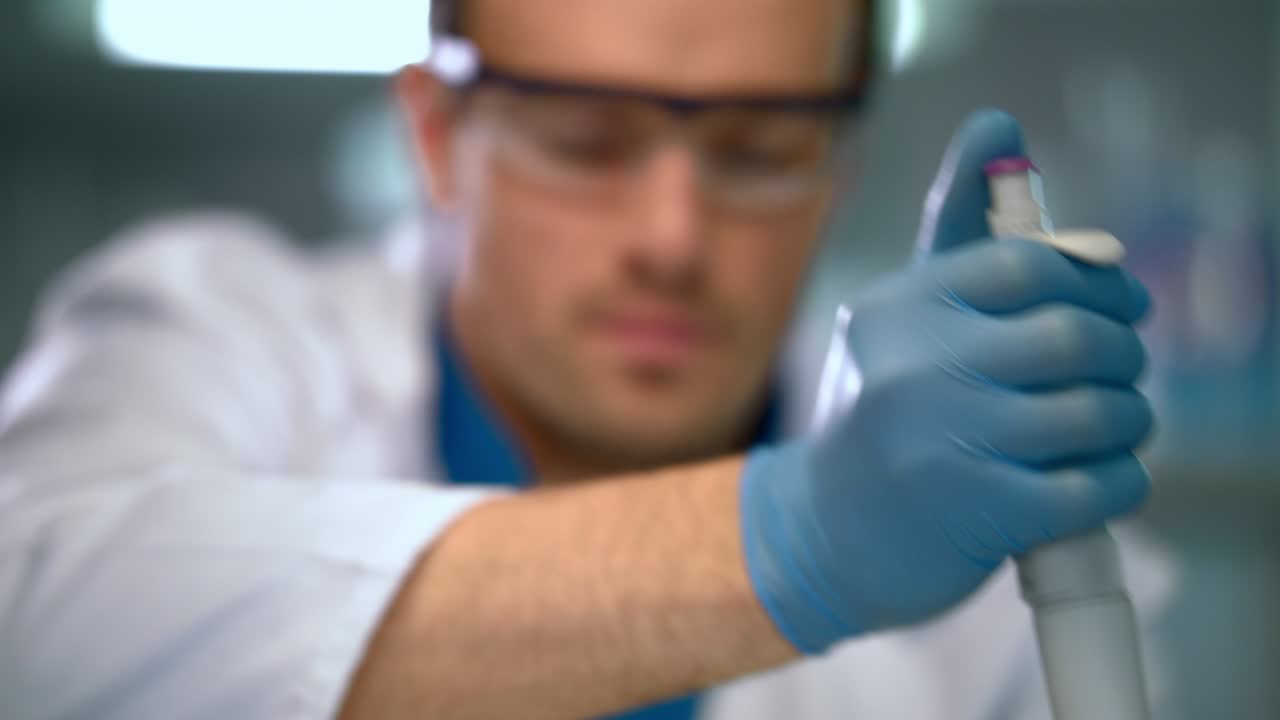 Medico che usa una micropipetta in laboratorio. Primo piano di scienziato che lavora in laboratorio