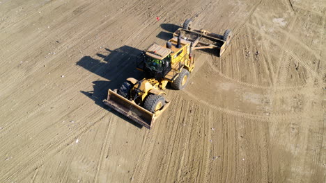 aerial view of a landfill compactor working on a dirt site