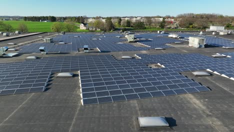 Sideways-aerial-of-large-solar-panel-installation-on-industrial-rooftop