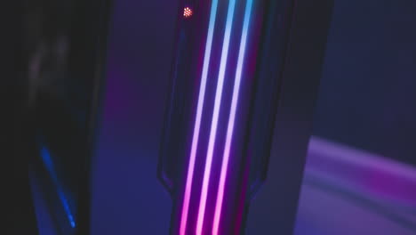 close up of speaker system with glowing vertical led stripes in green and yellow tones, placed in dimly lit tech room with colorful reflections and modern lighting ambiance