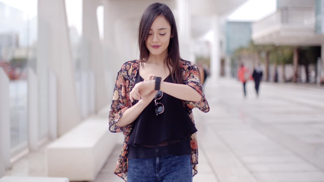 una mujer joven chequeando su reloj de muñeca.