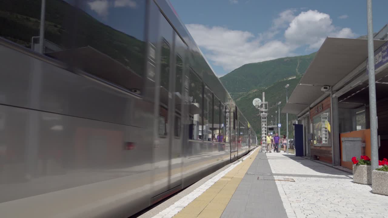 A train leaving the station on a nice and sunny summer's day in Laas - Lasa, South Tyrol, Italy. Lasa Marmo can be seen in the background.