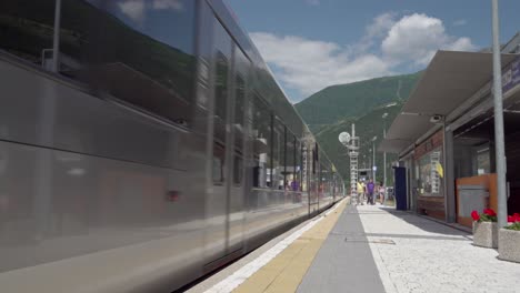 a train leaving the station on a nice and sunny summer's day in laas - lasa, south tyrol, italy. lasa marmo can be seen in the background.