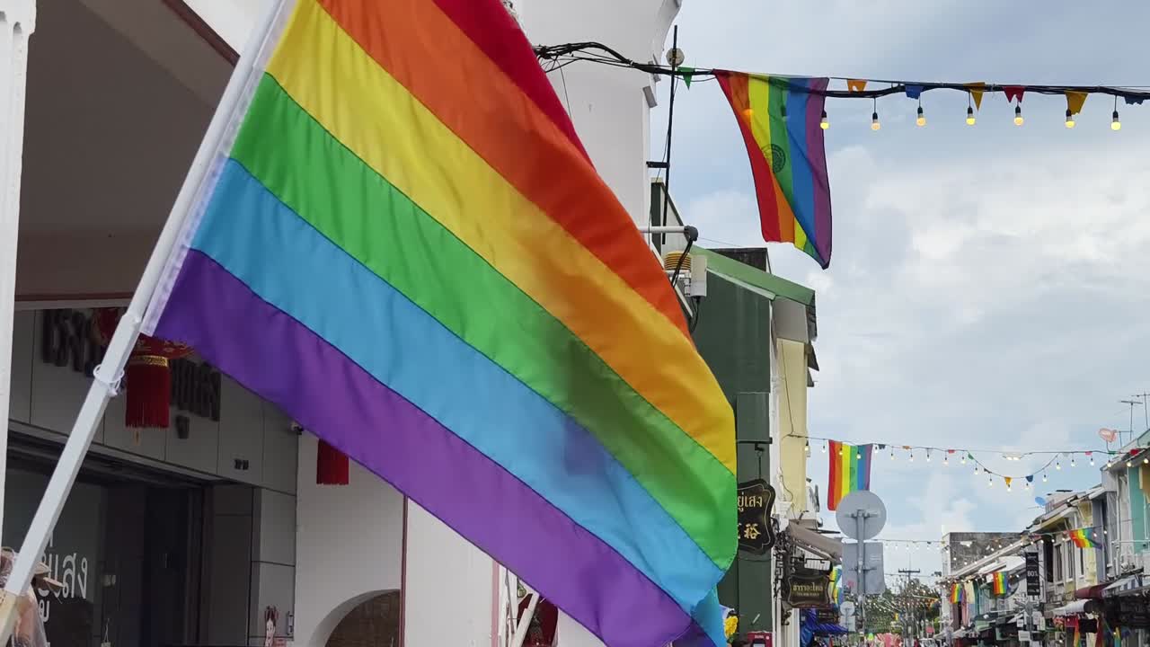 las banderas del arco iris decoran una calle tailandesa.
