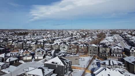 Aerial-view-of-a-suburban-community-at-sunset-in-Calgary,-Alberta-in-winter,-with-Chinook-Clouds