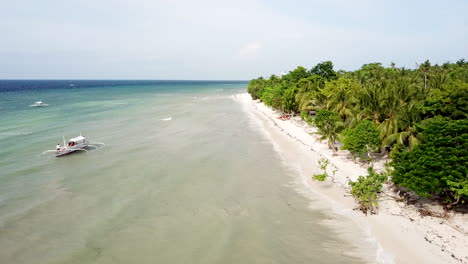 Luftaufnahmen-Entlang-Eines-Wunderschönen-Weißen-Sandstrandes-Mit-Palmen-Und-Türkisfarbenem-Wasser-Mit-Traditionellen-Fischerbooten-Auf-Der-Insel-Panglao-Auf-Den-Philippinen