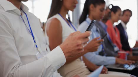 audiencia en una conferencia de negocios usando teléfonos y computadoras