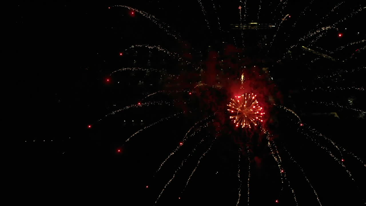 Slow Motion Aerial of Fireworks Over Small Town