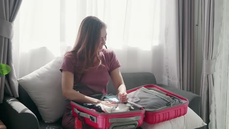 cute woman happily zipping a suitcase smiling with her passport and credit card